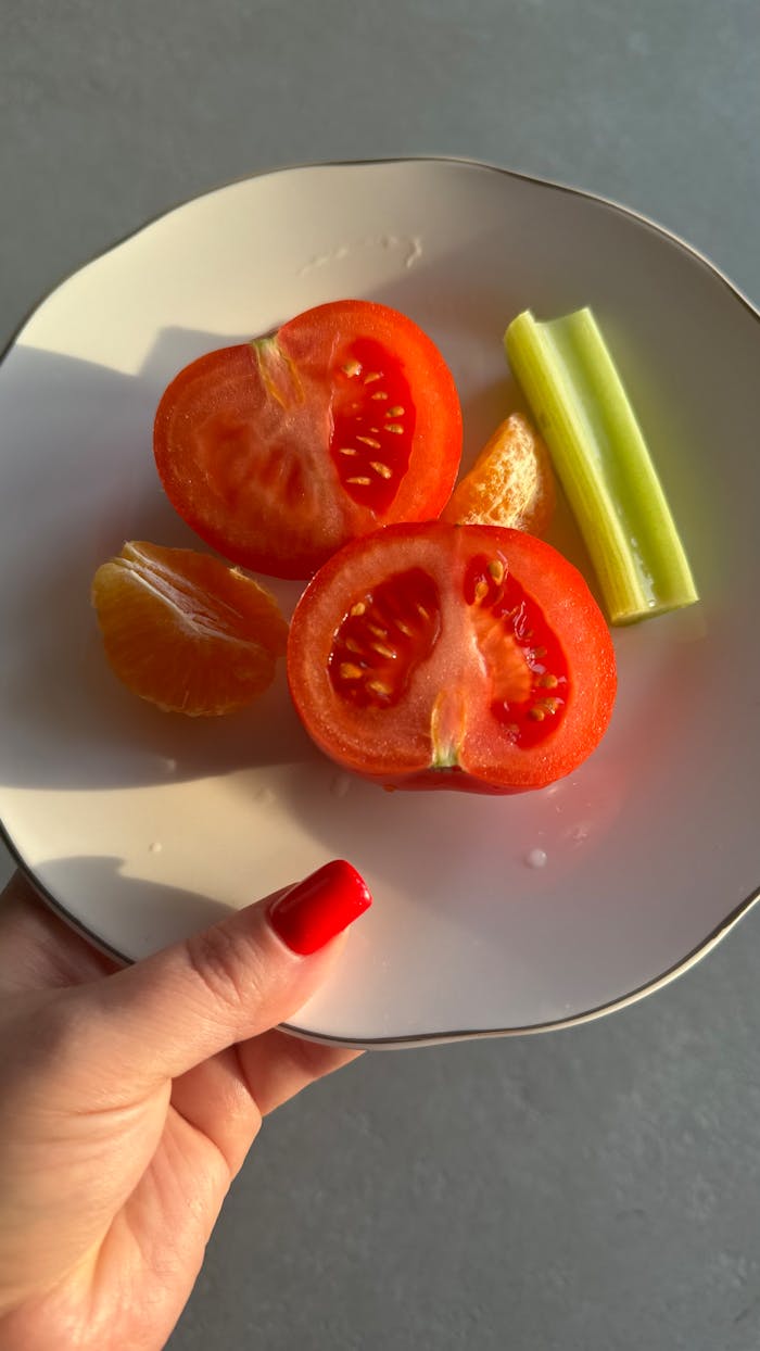Mastering the First Impression: Your intriguing post title goes here A healthy mix of fresh tomato, celery, and orange on a plate in natural light.