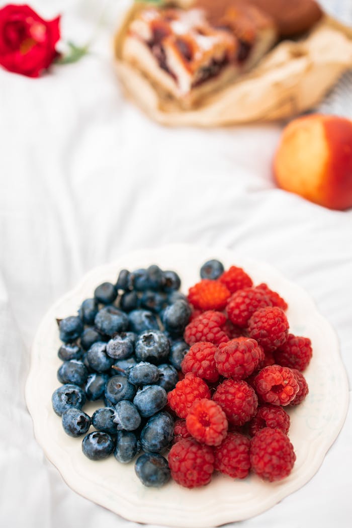 A healthy assortment of fresh blueberries and raspberries on a plate, perfect for nutritious snacking.